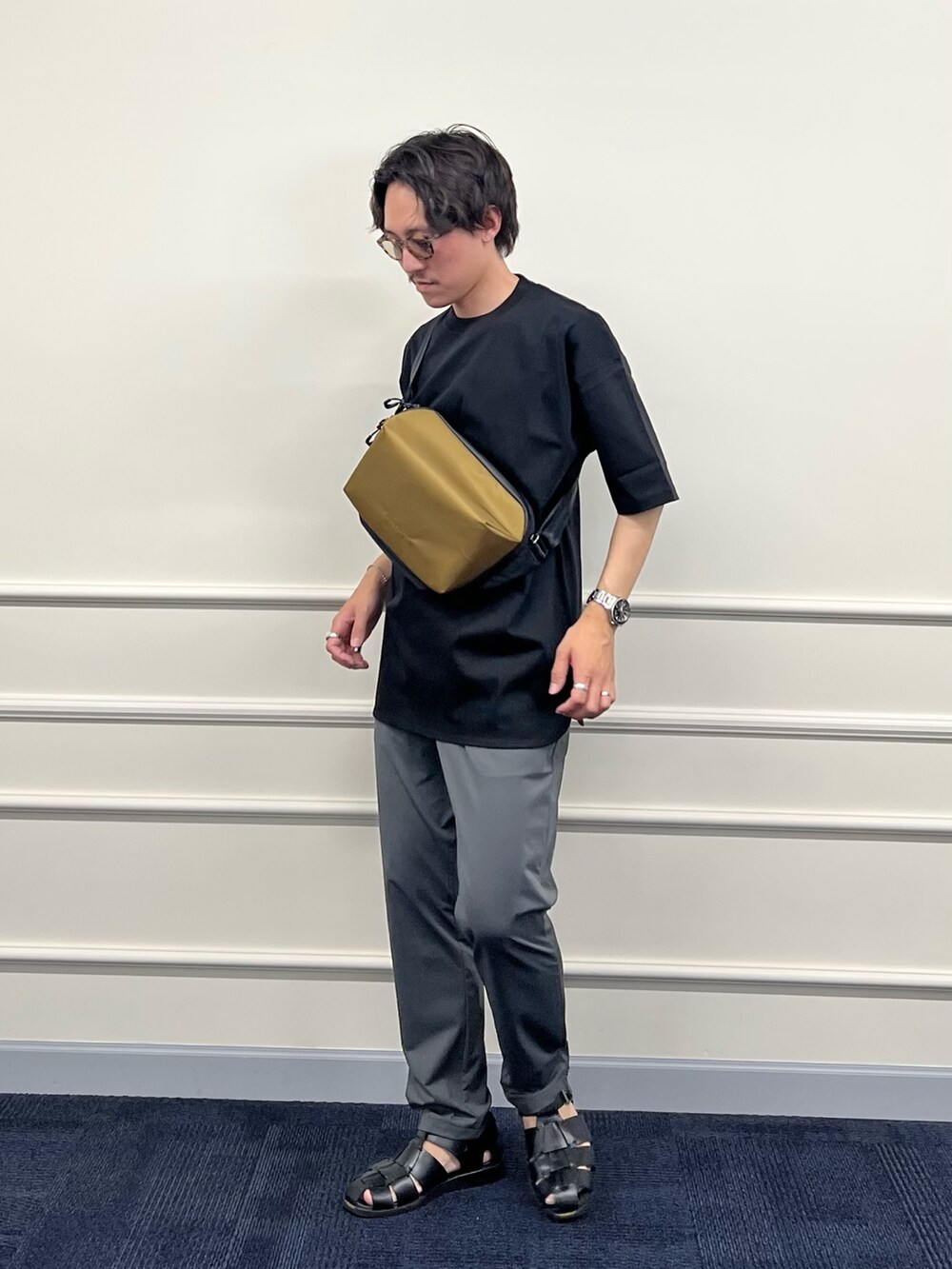 ブラック系のTシャツ/カットソー、グリーン系のショルダーバッグ、グレー系のその他パンツを着用したメンズの春コーディネートの3枚目の写真