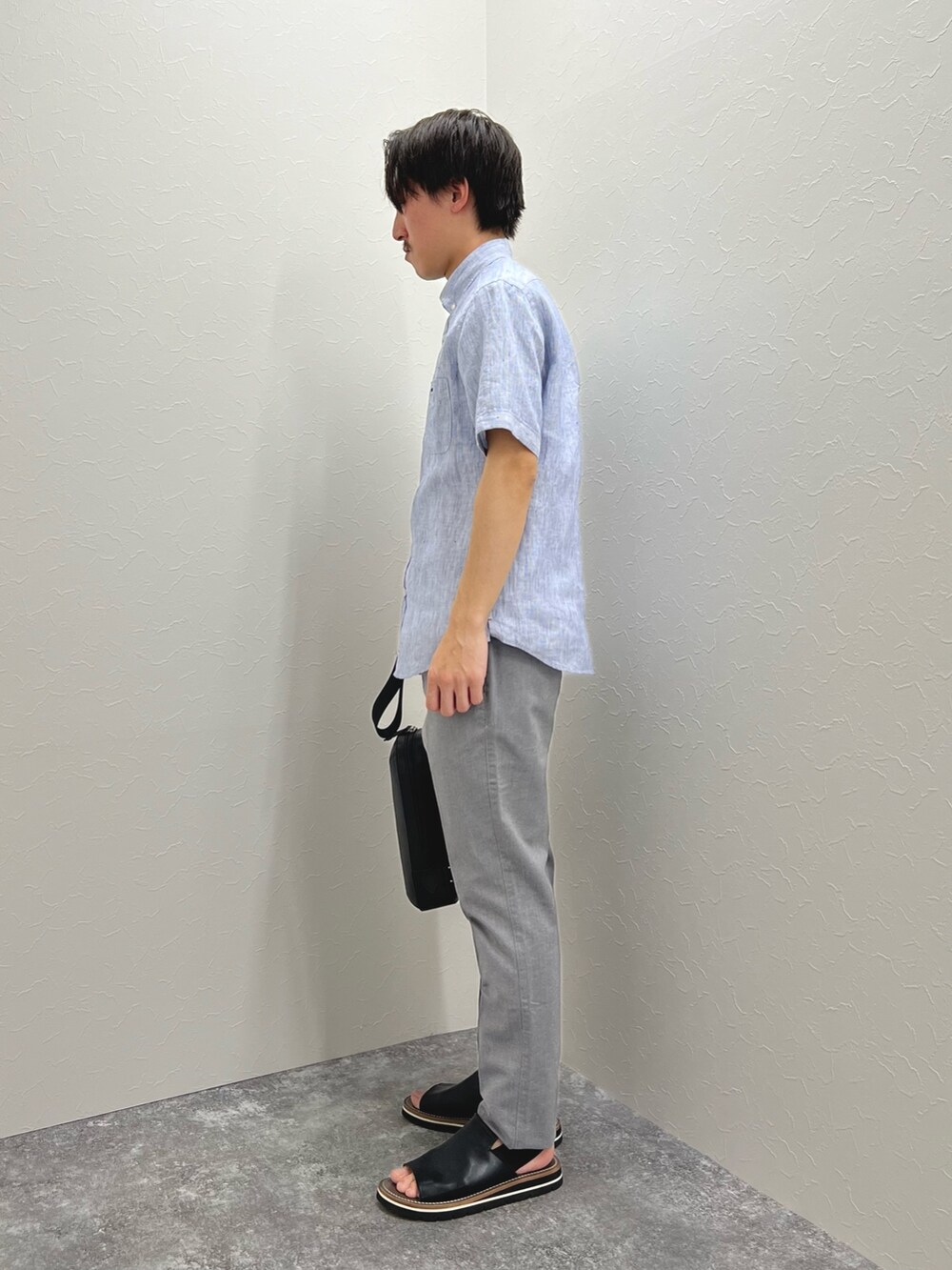 ブルー系のシャツ/ブラウス、ブラック系のボディバッグ/ウエストポーチ、グレー系のチノパンツを着用したメンズの春コーディネートの4枚目の写真