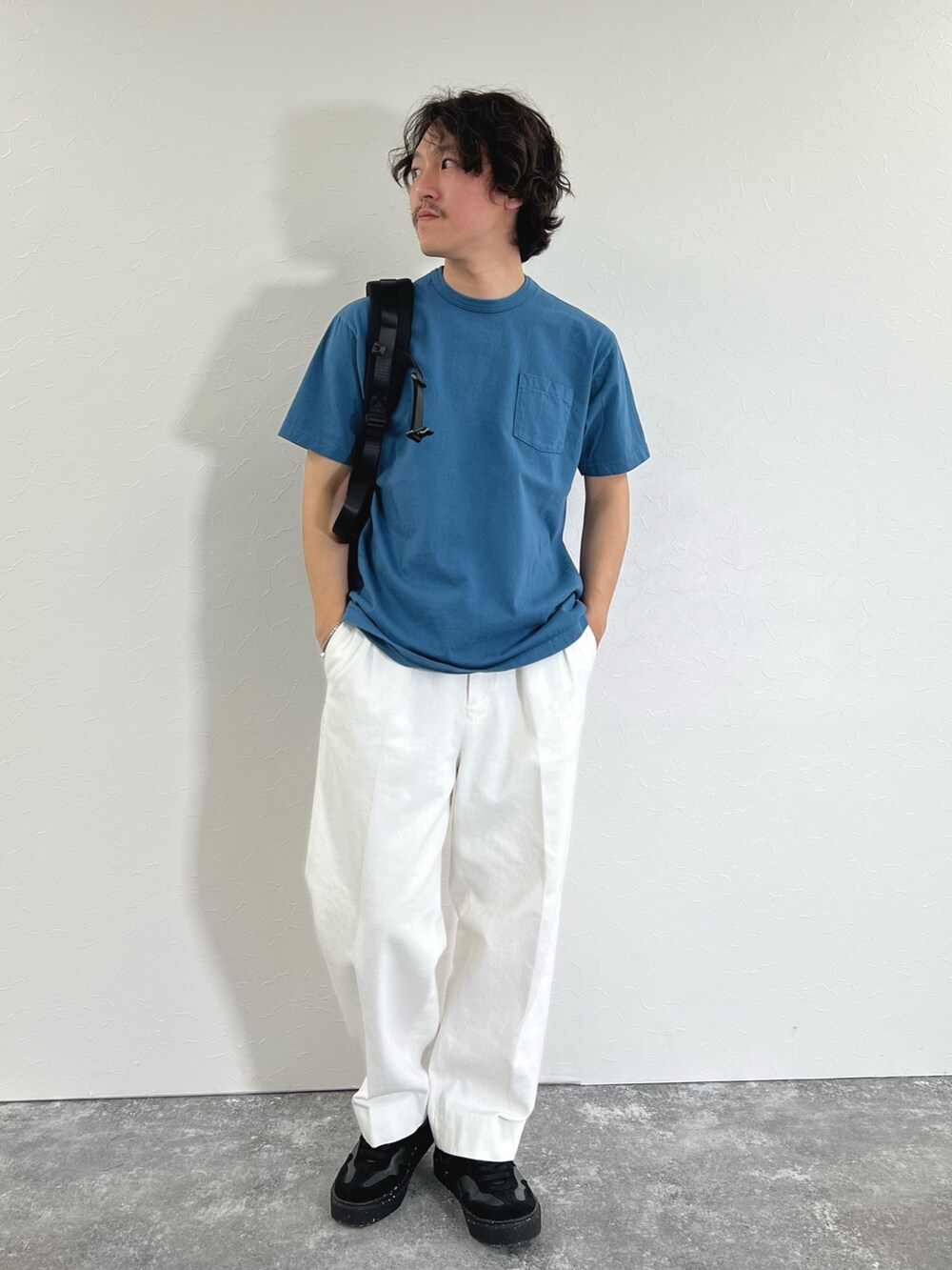 ブルー系のTシャツ/カットソー、ブラック系のショルダーバッグ、ホワイト系のデニムパンツを着用したメンズの春コーディネートの2枚目の写真