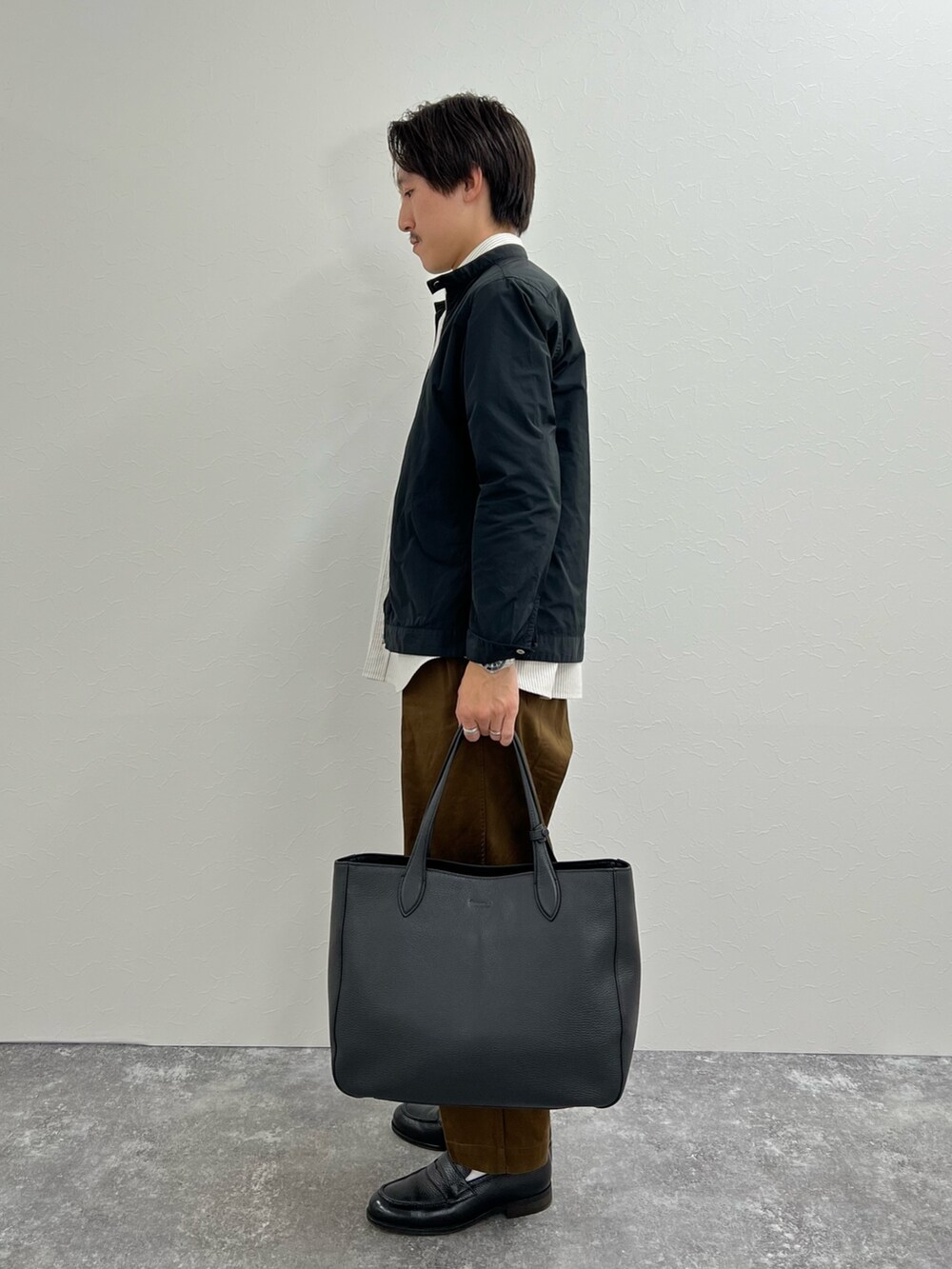 ブラック系のシャツ/ブラウス、ベージュ系のシャツ/ブラウス、ブラック系のトートバッグを着用したメンズの秋コーディネートの4枚目の写真