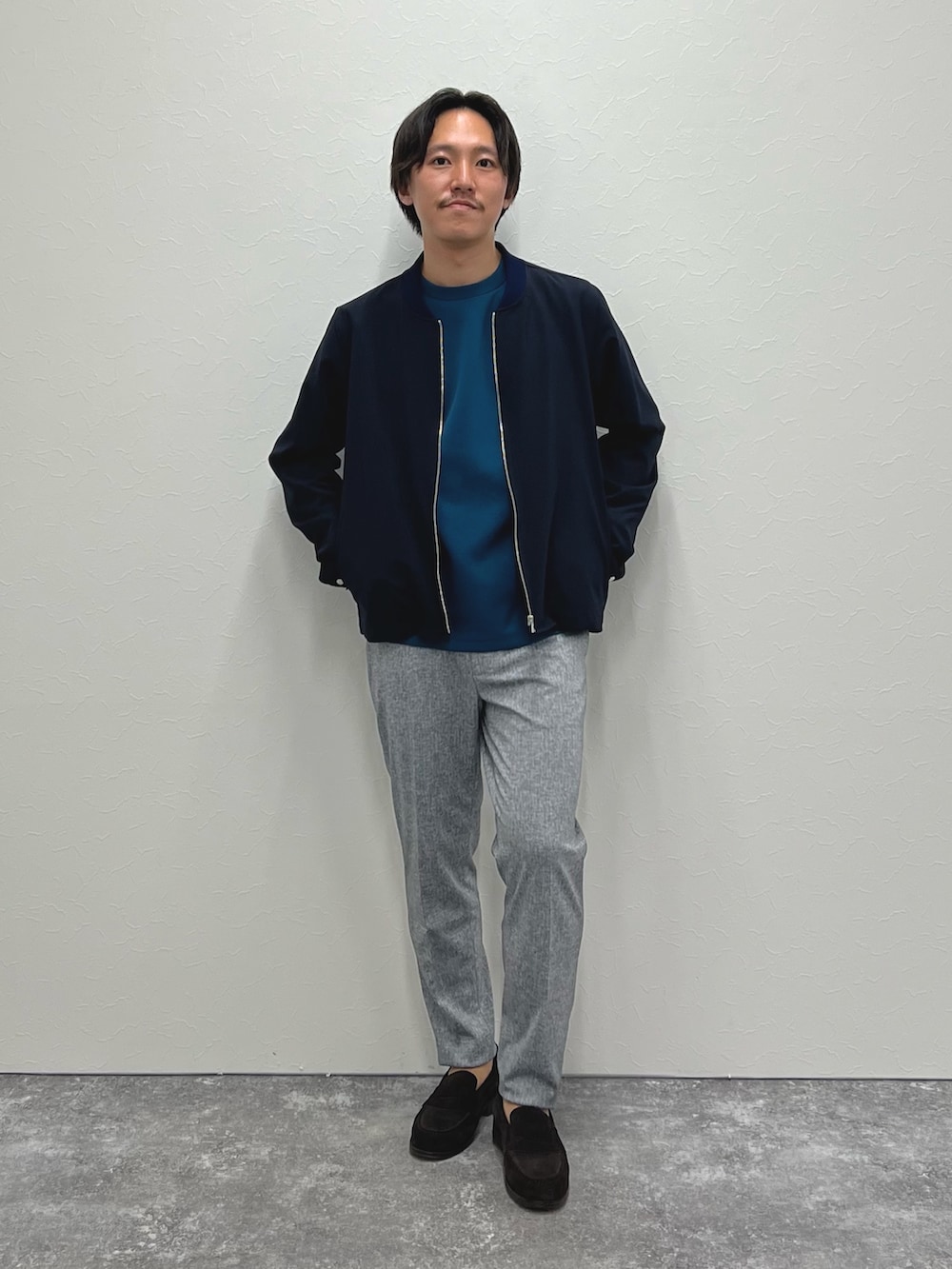 ブルー系のブルゾン、ブルー系のTシャツ/カットソー、グレー系のその他パンツを着用したメンズの秋コーディネートの2枚目の写真