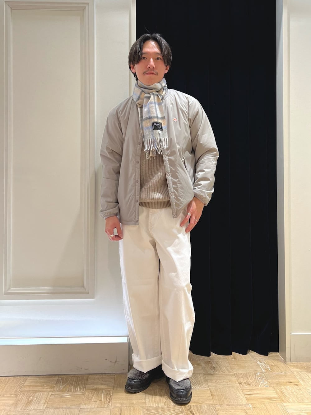 グレー系のブルゾン、ブラック系のシューズ、グレー系のマフラーを着用したメンズの冬コーディネートの2枚目の写真
