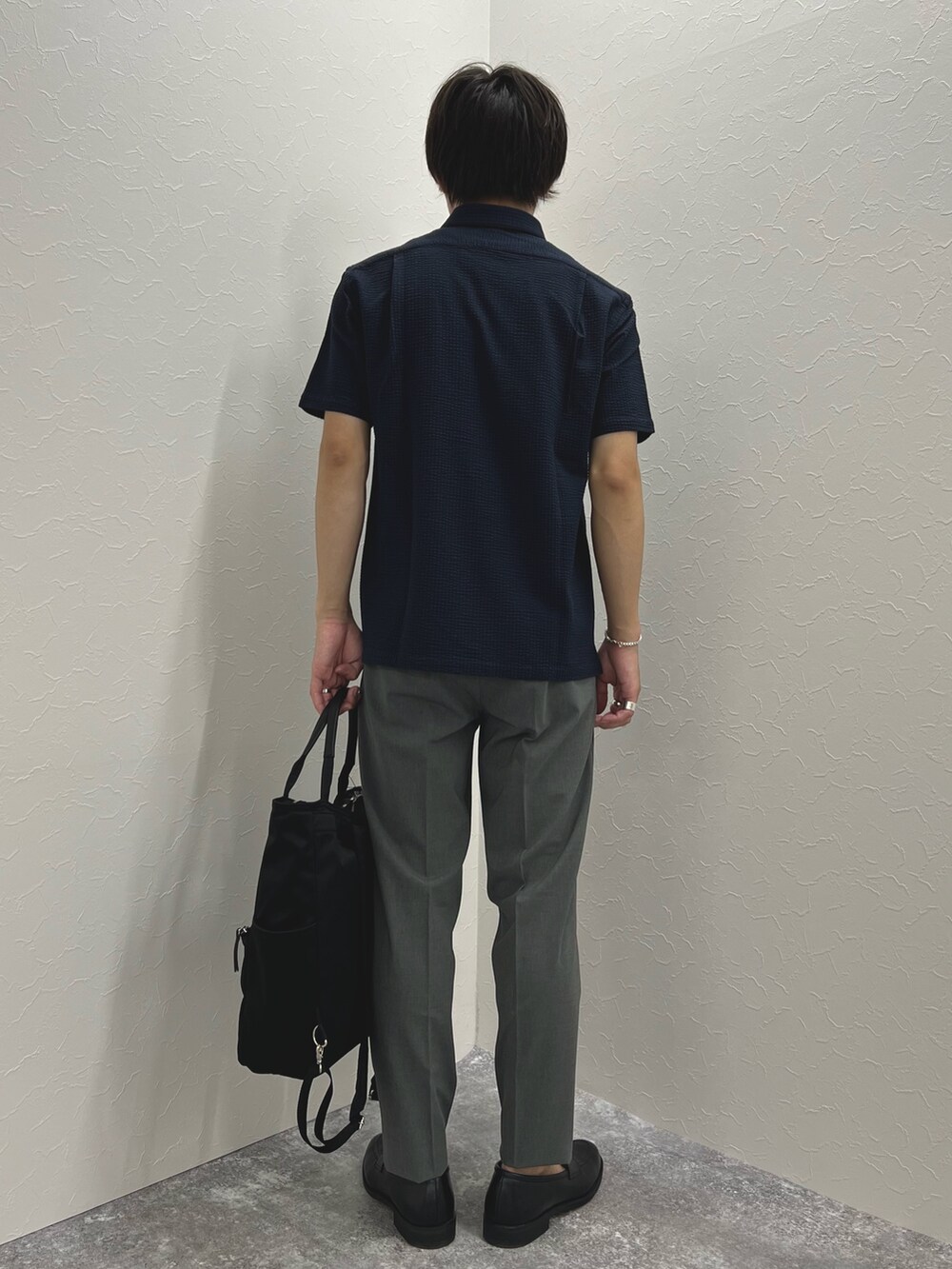 ブルー系のポロシャツ、グレー系のその他パンツ、ブラック系のトートバッグを着用したメンズの夏コーディネートの6枚目の写真