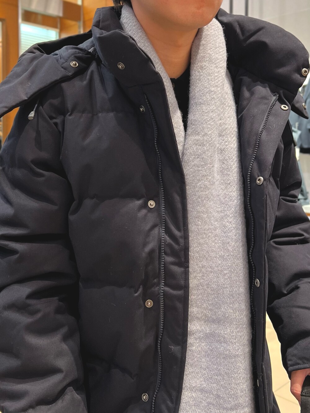 ブルー系のダウンジャケット/コート、ブラック系のトートバッグ、ブラック系のローファーを着用したメンズの冬コーディネートの7枚目の写真