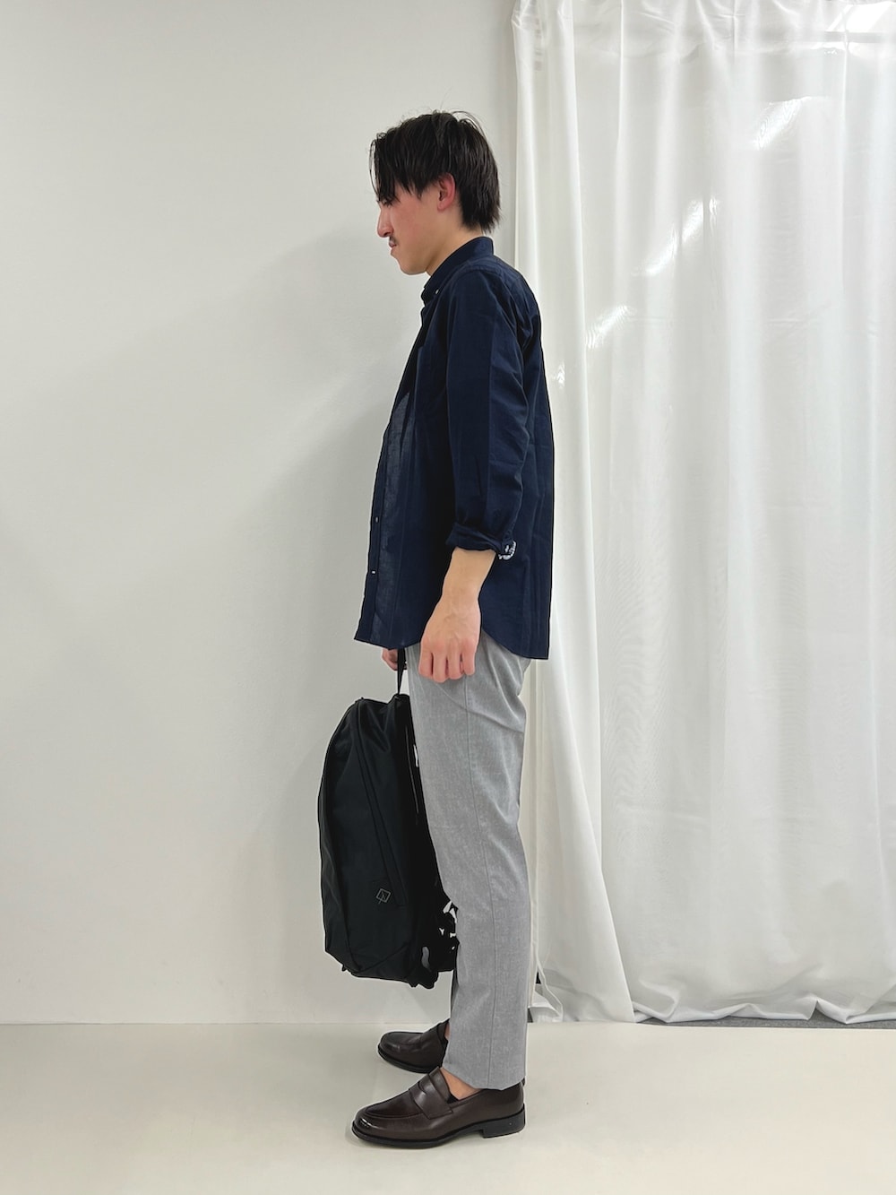 ブルー系のシャツ/ブラウス、ブラウン系のローファー、グレー系のチノパンツを着用したメンズの春コーディネートの4枚目の写真