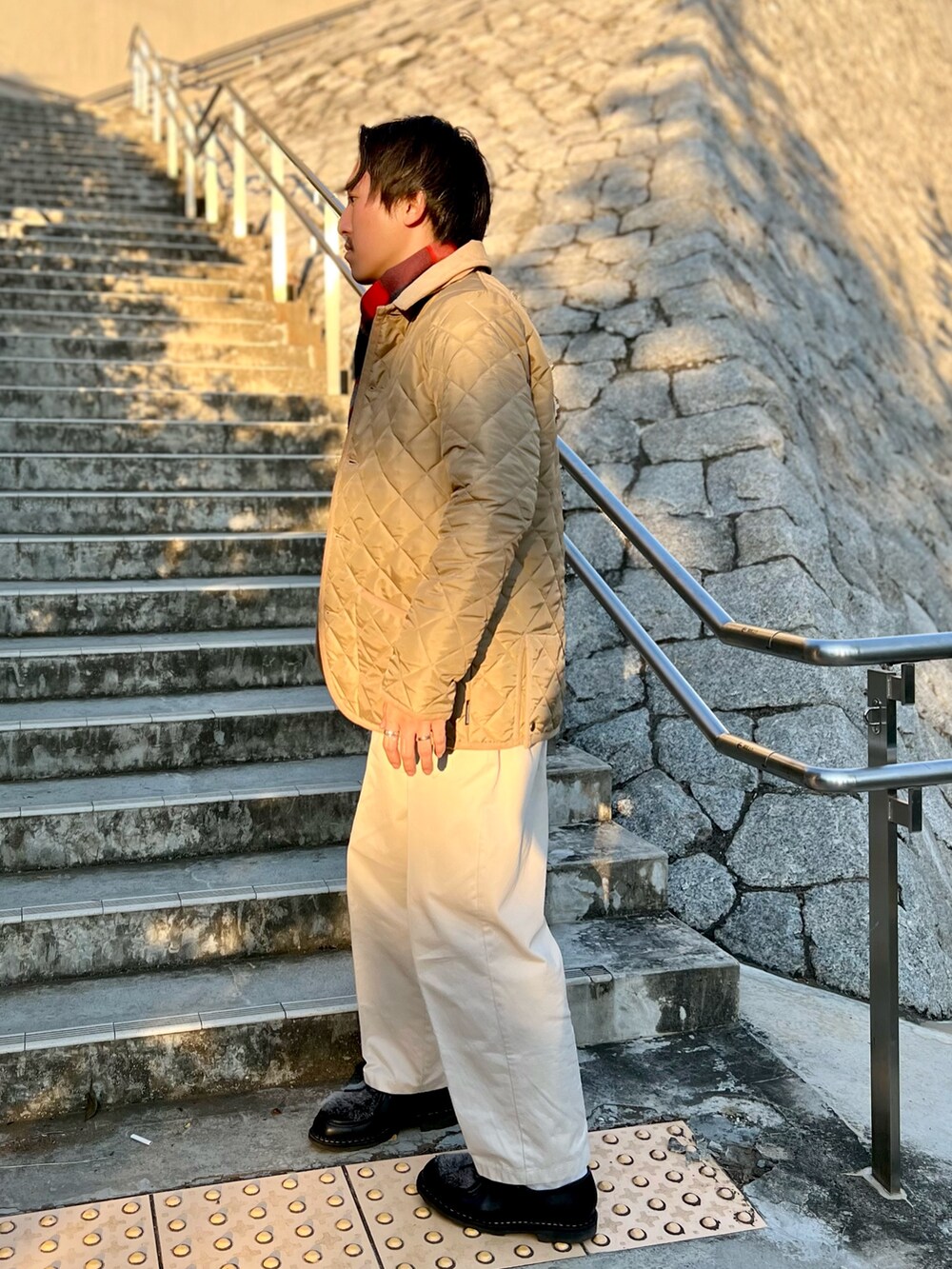 ベージュ系のブルゾン、ブルー系のマフラーを着用したメンズの秋コーディネートの4枚目の写真