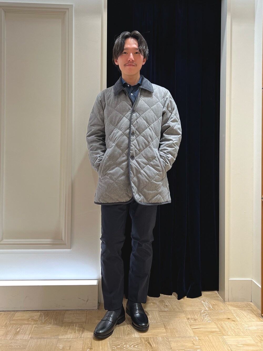 グレー系のダウンジャケット/コート、ブルー系のシャツ/ブラウス、ブラック系のローファーを着用したメンズの冬コーディネートの3枚目の写真