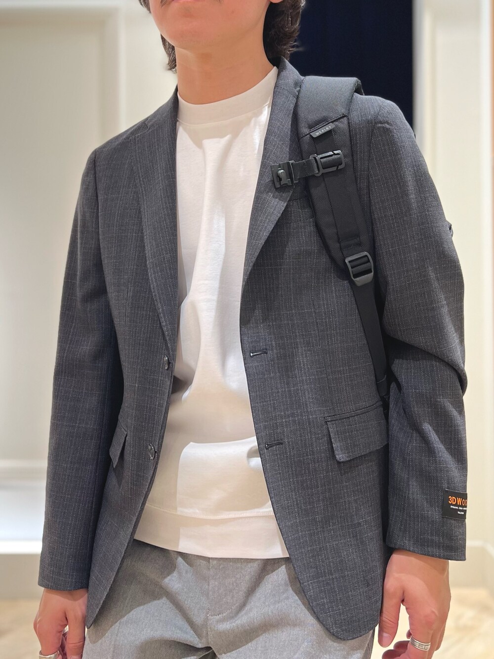 グレー系のテーラードジャケット、ホワイト系のTシャツ/カットソー、グレー系のチノパンツを着用したメンズの春コーディネートの8枚目の写真