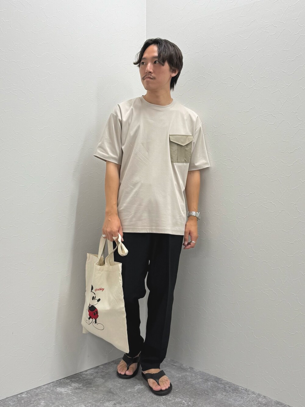 ベージュ系のTシャツ/カットソー、ホワイト系のトートバッグ、ブラック系のその他パンツを着用したメンズの夏コーディネートの2枚目の写真