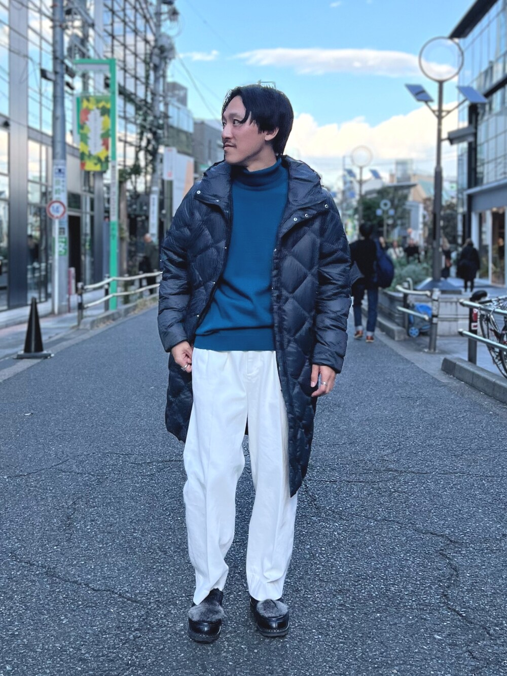 グレー系のダウンジャケット/コート、ブルー系のニット/セーター、ホワイト系のデニムパンツを着用したメンズの冬コーディネートの3枚目の写真