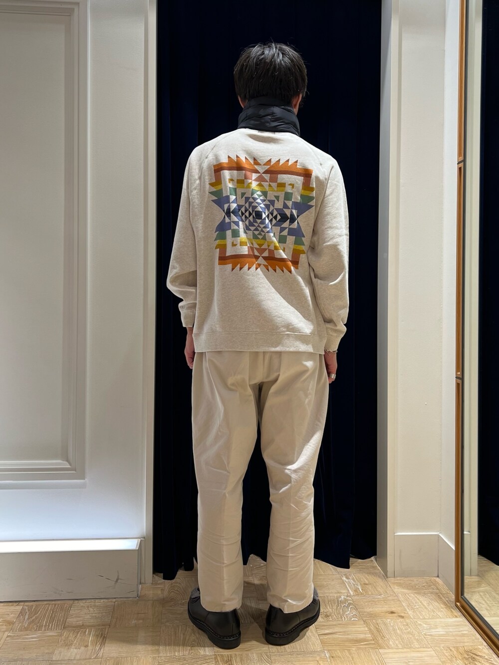 ホワイト系のスウェット、ブラック系のマフラーを着用したメンズの秋コーディネートの2枚目の写真