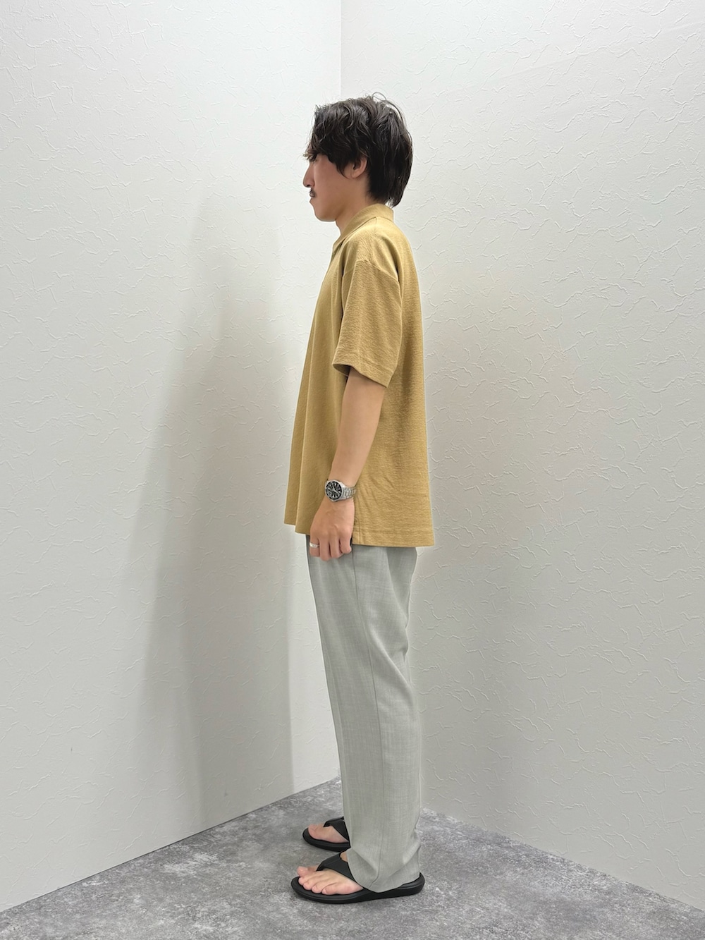 ベージュ系のポロシャツ、ブラック系のサンダルを着用したメンズの夏コーディネートの6枚目の写真