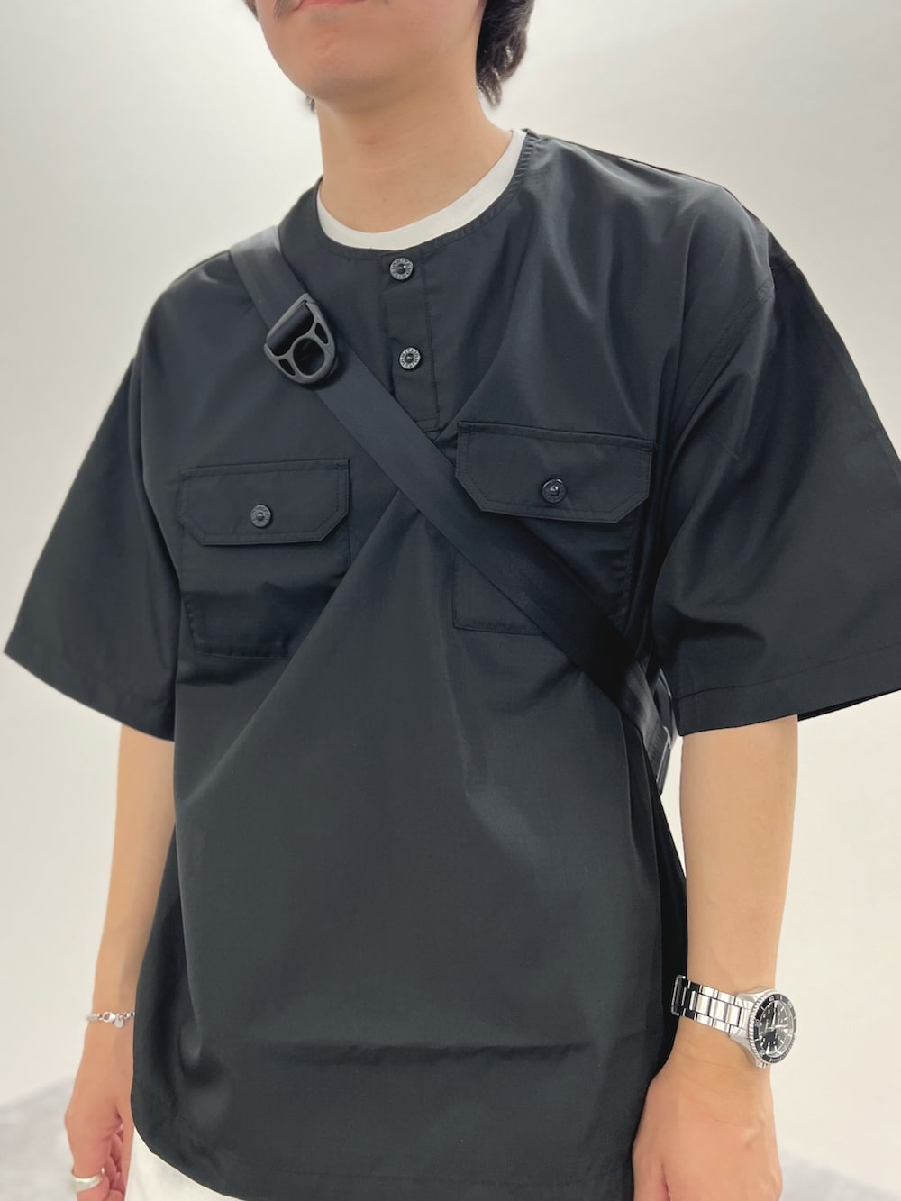 ブラック系のTシャツ/カットソー、ブルー系のショルダーバッグ、ホワイト系のデニムパンツを着用したメンズの春コーディネートの7枚目の写真