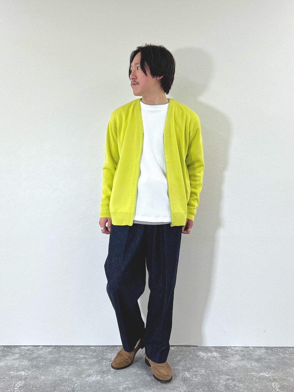 イエロー系のカーディガン/ボレロ、ホワイト系のTシャツ/カットソー、ブルー系のデニムパンツを着用したメンズの冬コーディネートの3枚目の写真