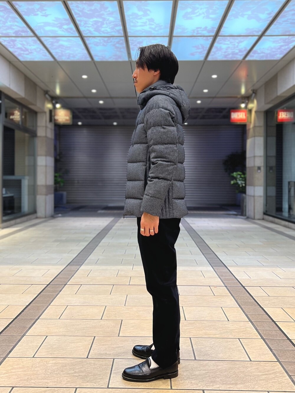 ブルー系のダウンジャケット/コート、ブルー系のニット/セーター、ブルー系のチノパンツを着用したメンズの秋コーディネートの4枚目の写真