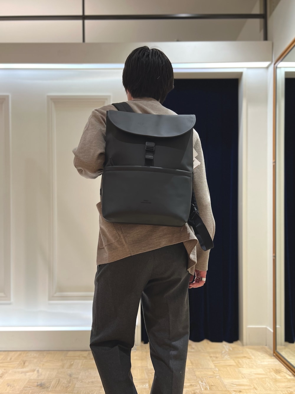 ベージュ系のテーラードジャケット、ブラック系のダウンベスト、ブラック系のバックパック/リュックを着用したメンズの冬コーディネートの10枚目の写真