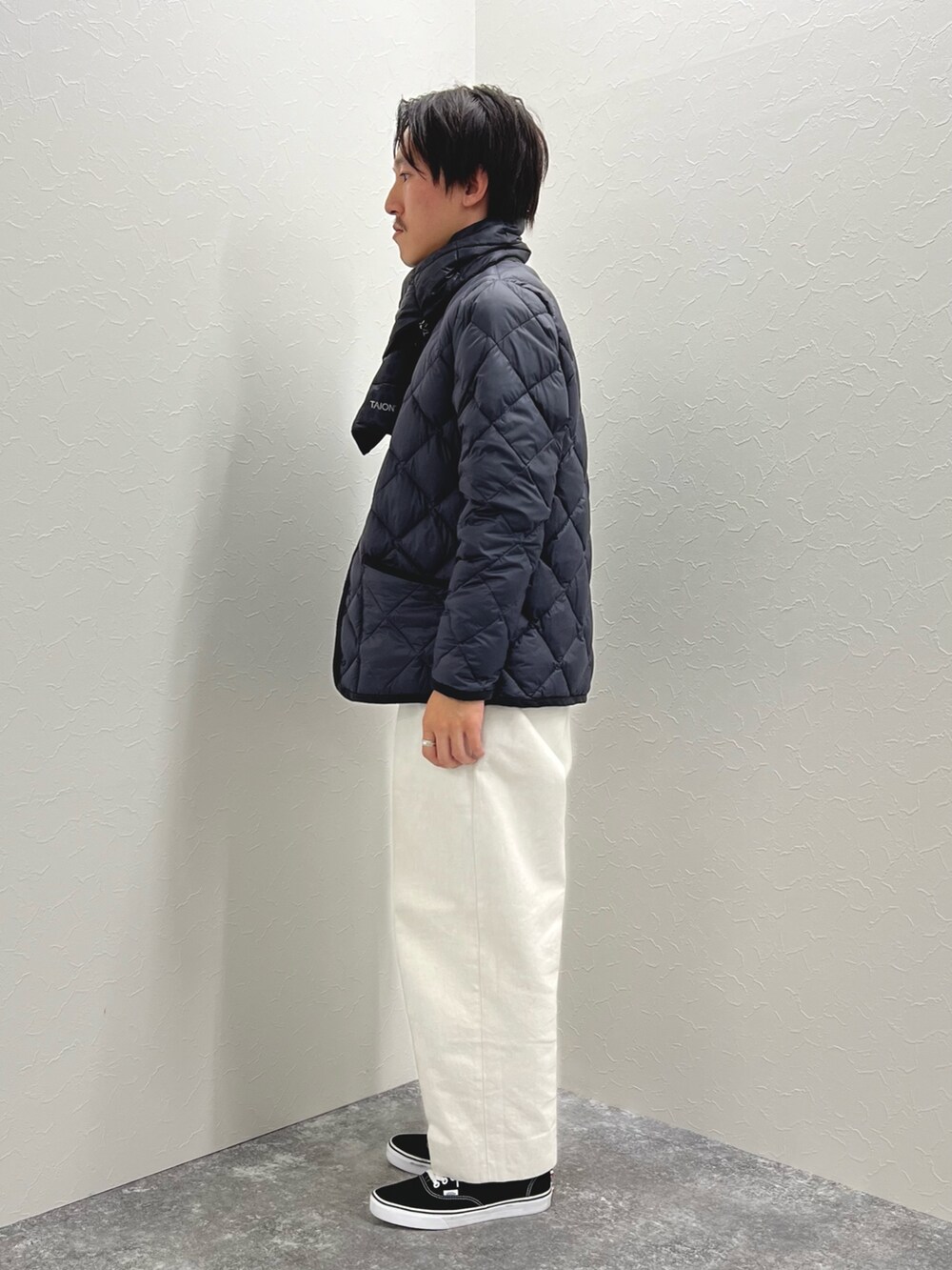 ブルー系のダウンジャケット/コート、グレー系のTシャツ/カットソー、ブルー系のマフラーを着用したメンズの秋コーディネートの4枚目の写真