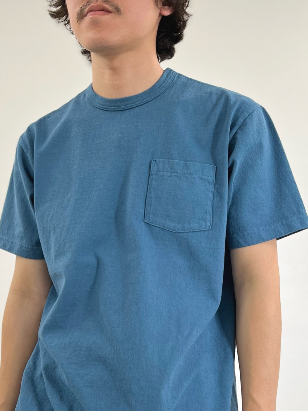 ブルー系のTシャツ/カットソー、ブラック系のショルダーバッグ、ホワイト系のデニムパンツを着用したメンズの春コーディネートの6枚目の写真