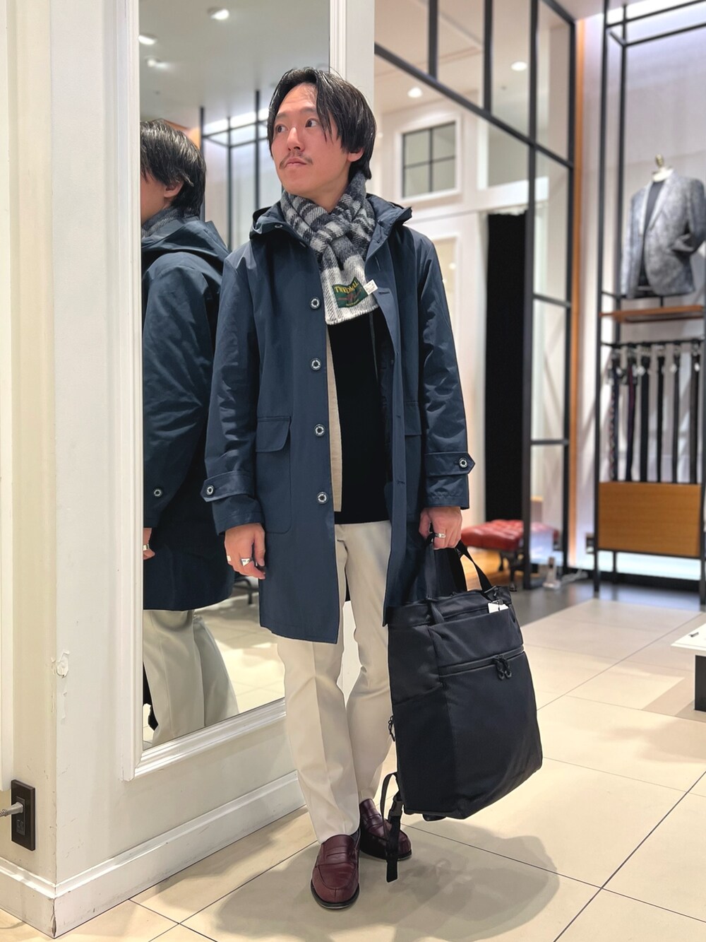 ブルー系のその他アウター、ブルー系のニット/セーター、ブラック系のトートバッグを着用したメンズの冬コーディネートの2枚目の写真