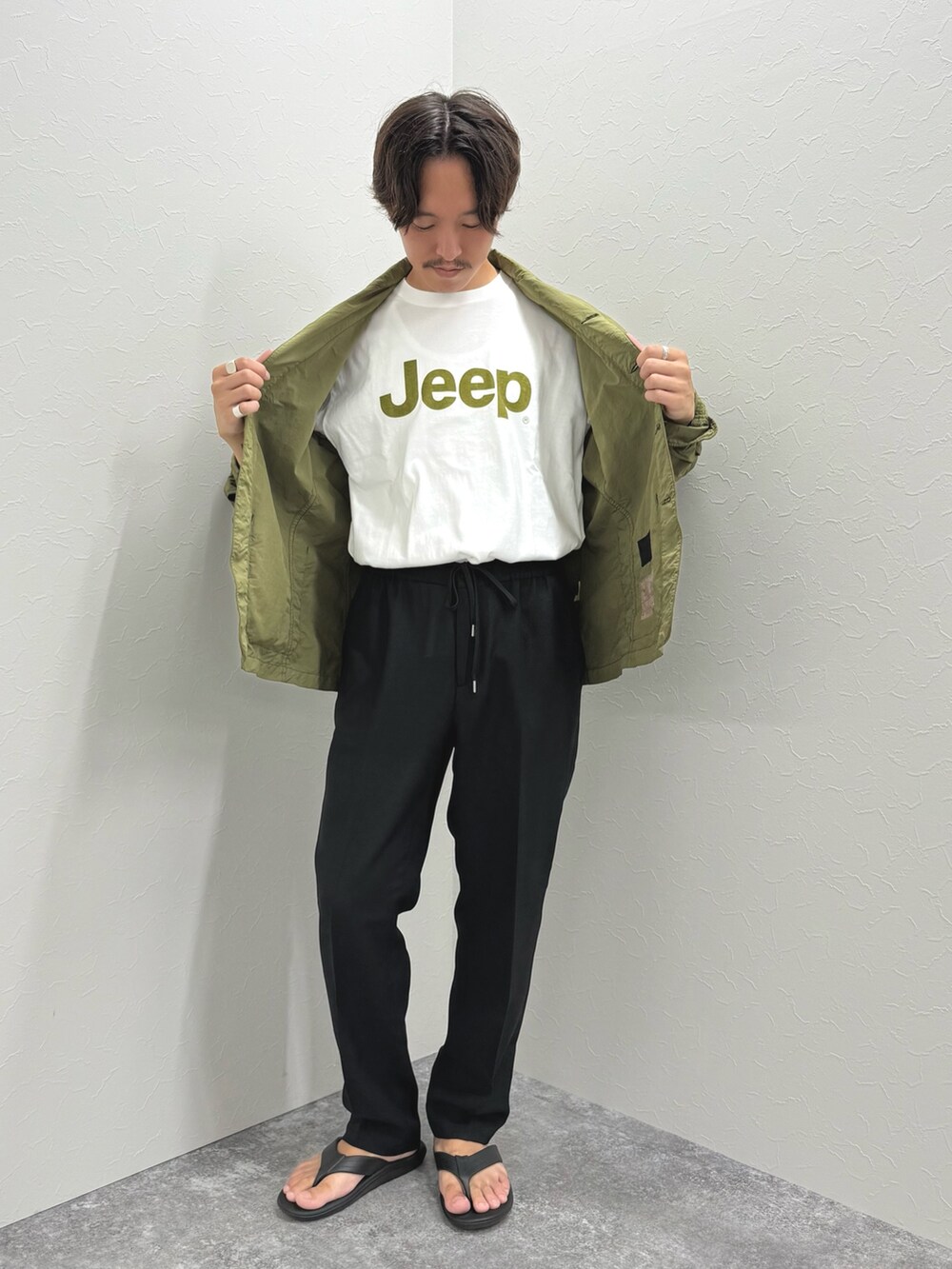 ホワイト系のTシャツ/カットソー、グリーン系のミリタリージャケット、ブラック系のその他パンツを着用したメンズの夏コーディネートの3枚目の写真