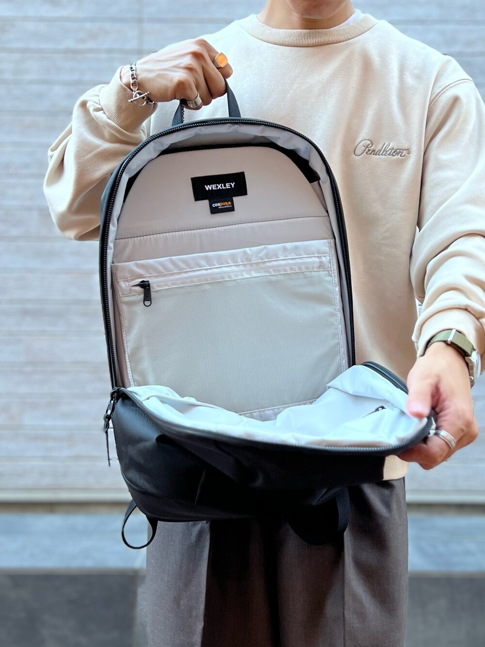 ホワイト系のスウェット、ブラック系のバックパック/リュックを着用したメンズの秋コーディネートの4枚目の写真