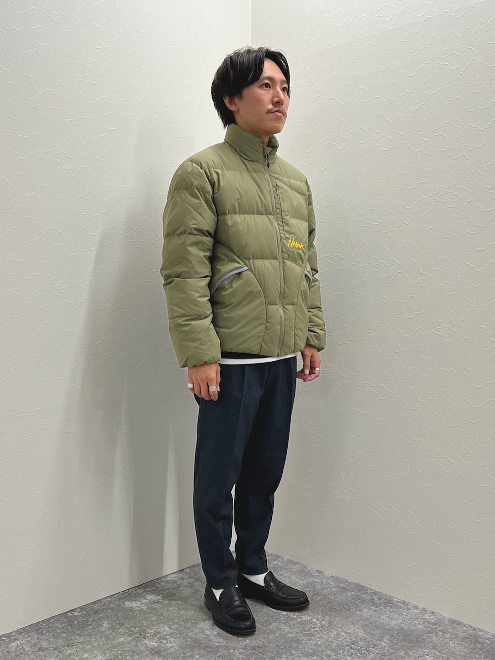 グリーン系のダウンジャケット/コート、ブルー系のTシャツ/カットソー、グレー系のその他パンツを着用したメンズの秋コーディネートの3枚目の写真