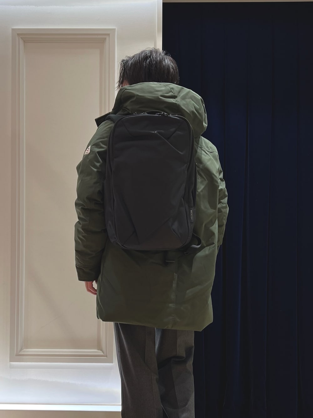 グリーン系のシャツ/ブラウス、ブラック系のバックパック/リュック、グリーン系のダウンジャケット/コートを着用したメンズの冬コーディネートの9枚目の写真