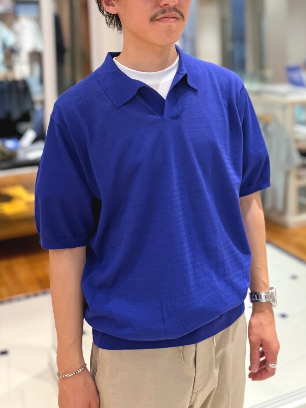 ブルー系のポロシャツ、ベージュ系のその他パンツ、ブラウン系のローファーを着用したメンズの春コーディネートの8枚目の写真