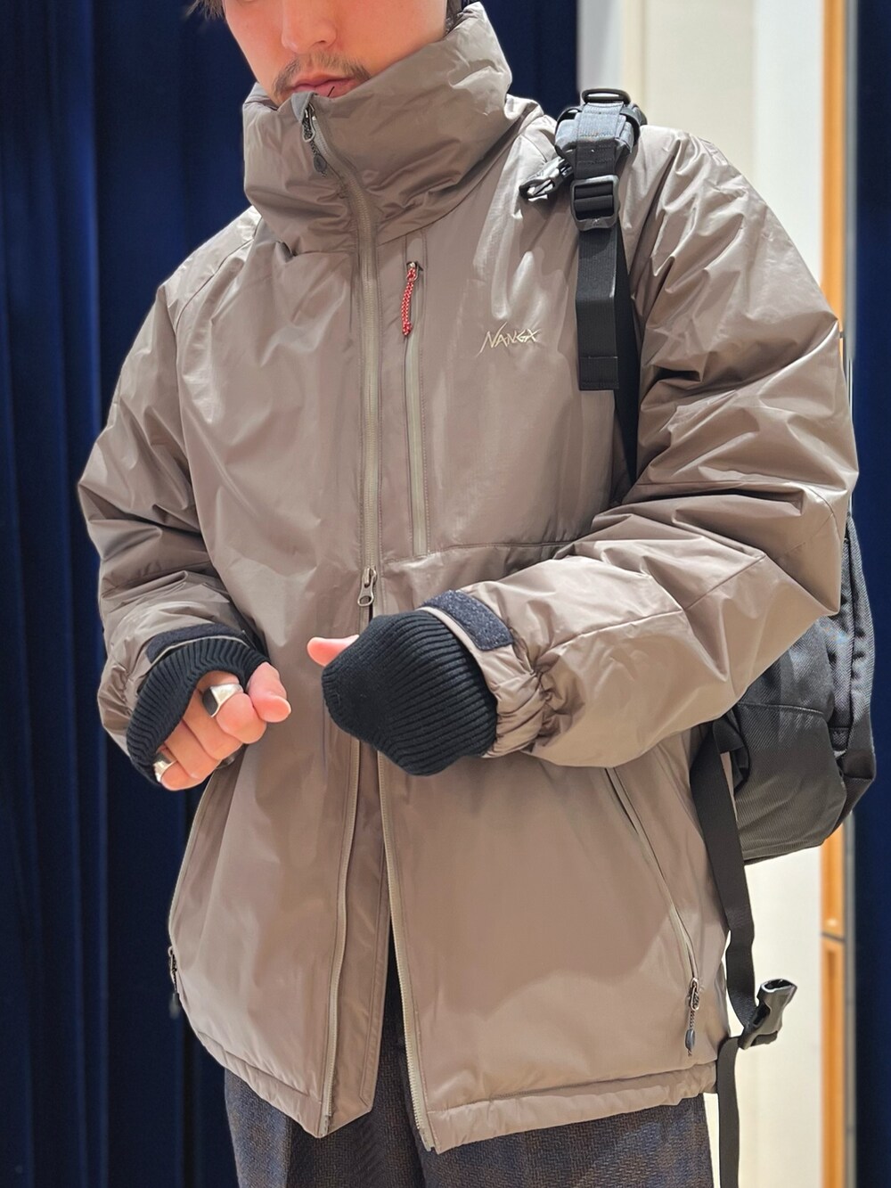 グレー系のダウンジャケット/コート、ブラック系のバックパック/リュックを着用したメンズの冬コーディネートの6枚目の写真