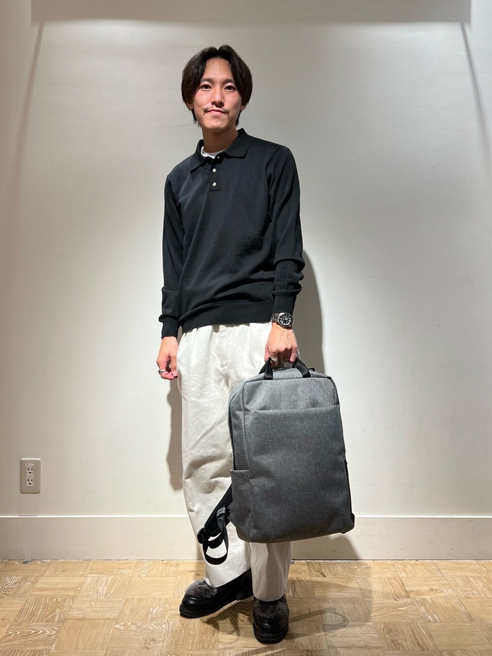 ブラック系のシューズ、ブラック系のニット/セーター、グレー系のバックパック/リュックを着用したメンズの秋コーディネートの2枚目の写真