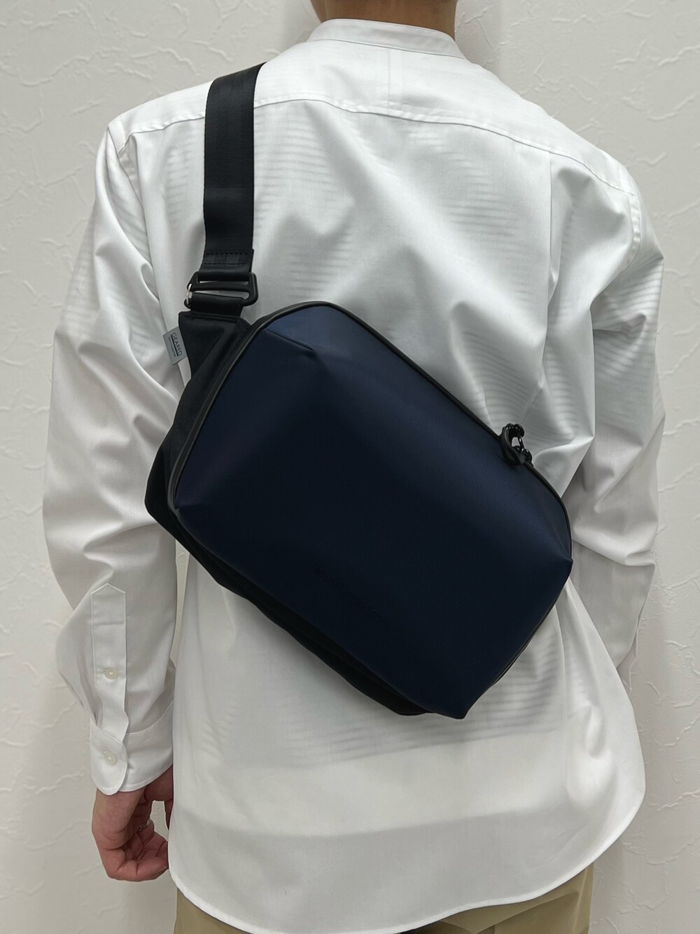 ホワイト系のシャツ/ブラウス、ベージュ系のその他パンツ、ブルー系のショルダーバッグを着用したメンズの春コーディネートの6枚目の写真