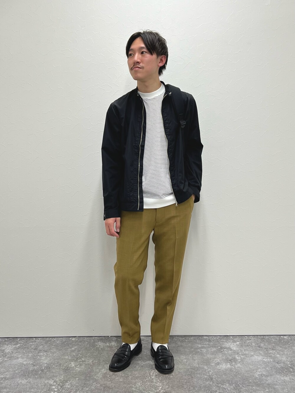 ブラック系のブルゾン、ベージュ系のその他パンツ、ブラック系のサンダルを着用したメンズの春コーディネートの2枚目の写真