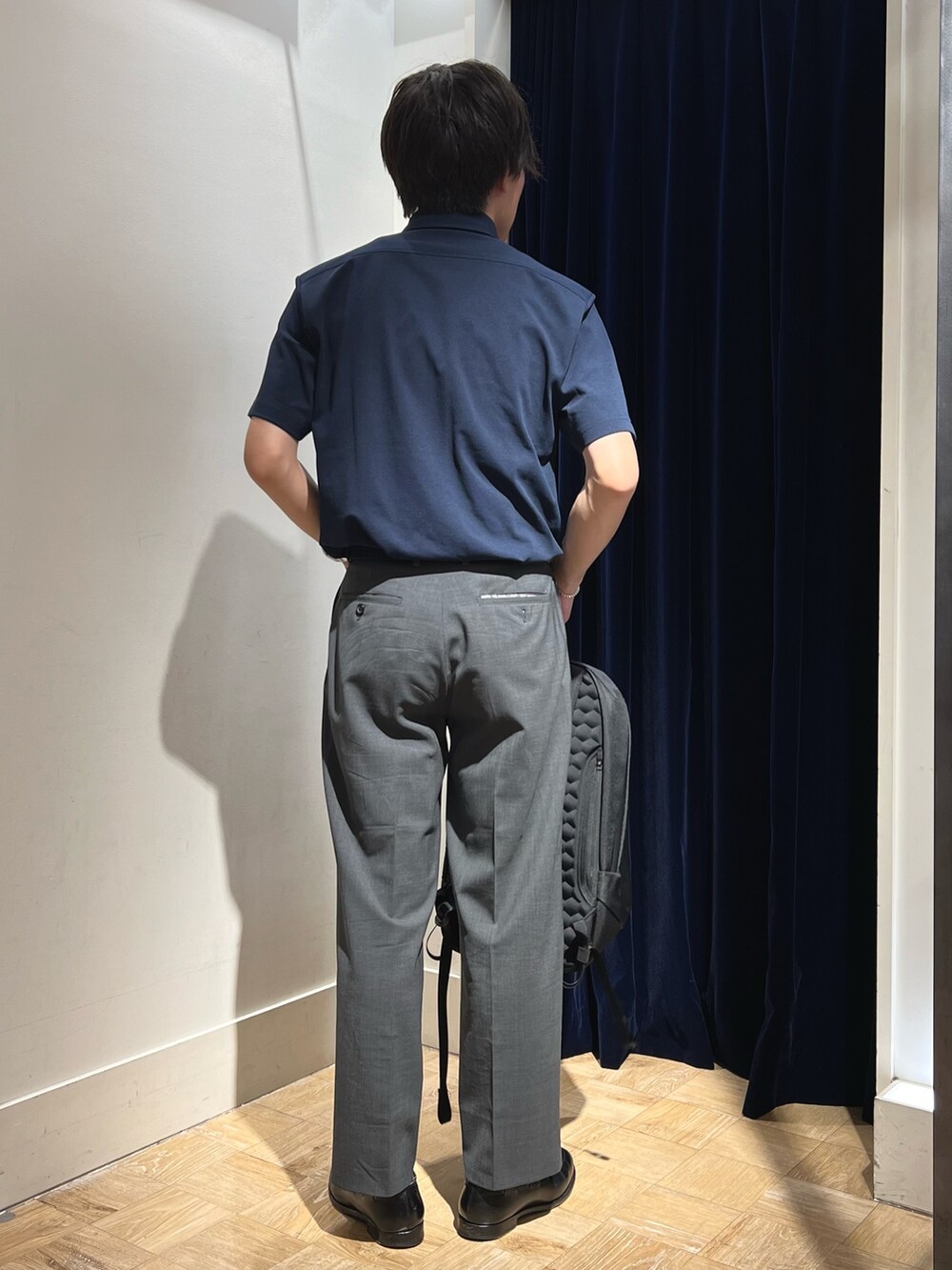 ブルー系のポロシャツ、ブラック系のバックパック/リュック、ブラック系のベルトを着用したメンズの夏コーディネートの5枚目の写真