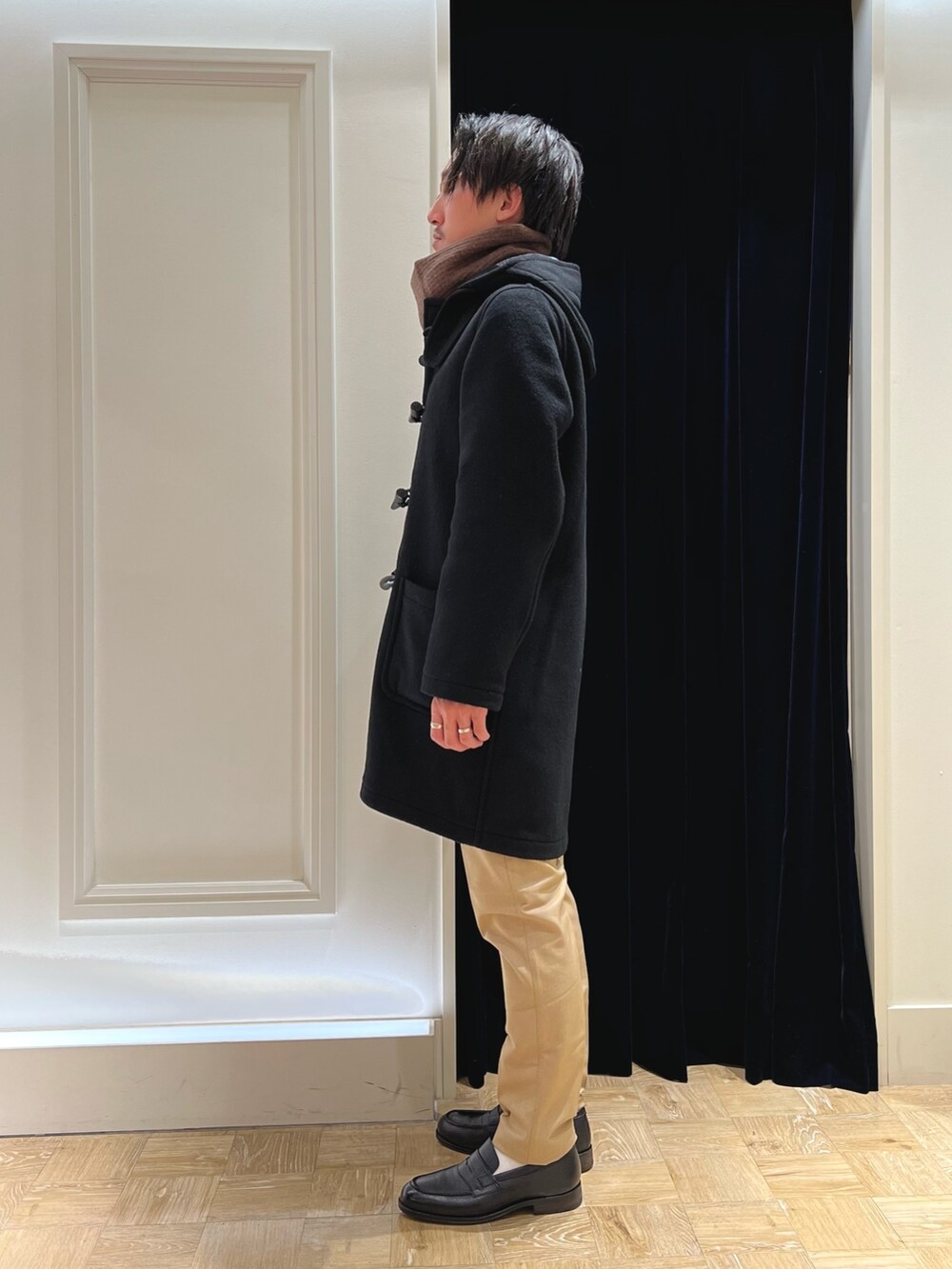 ブラック系のシャツ/ブラウス、ブラック系のダッフルコート、ベージュ系のその他パンツを着用したメンズの冬コーディネートの5枚目の写真