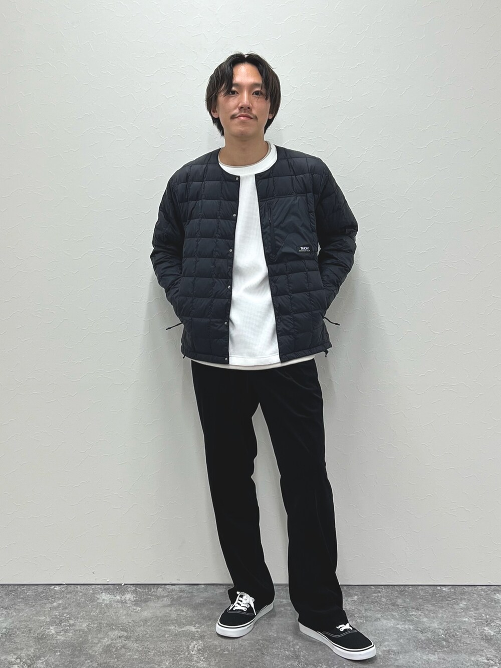ブラック系のダウンジャケット/コート、ホワイト系のTシャツ/カットソーを着用したメンズの秋コーディネートの2枚目の写真