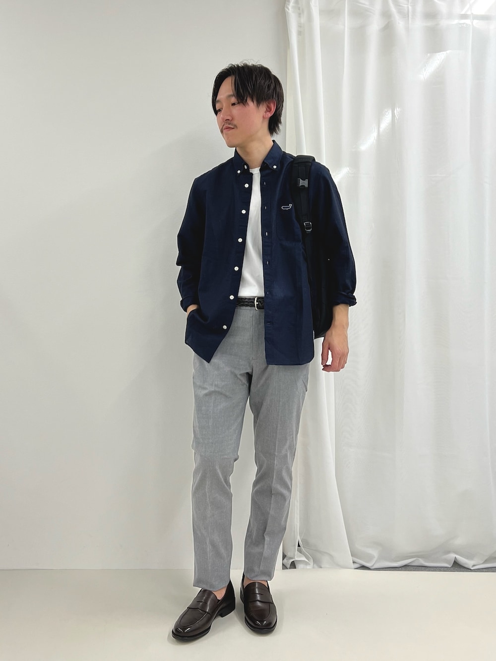 ブルー系のシャツ/ブラウス、ブラウン系のローファー、グレー系のチノパンツを着用したメンズの春コーディネートの2枚目の写真