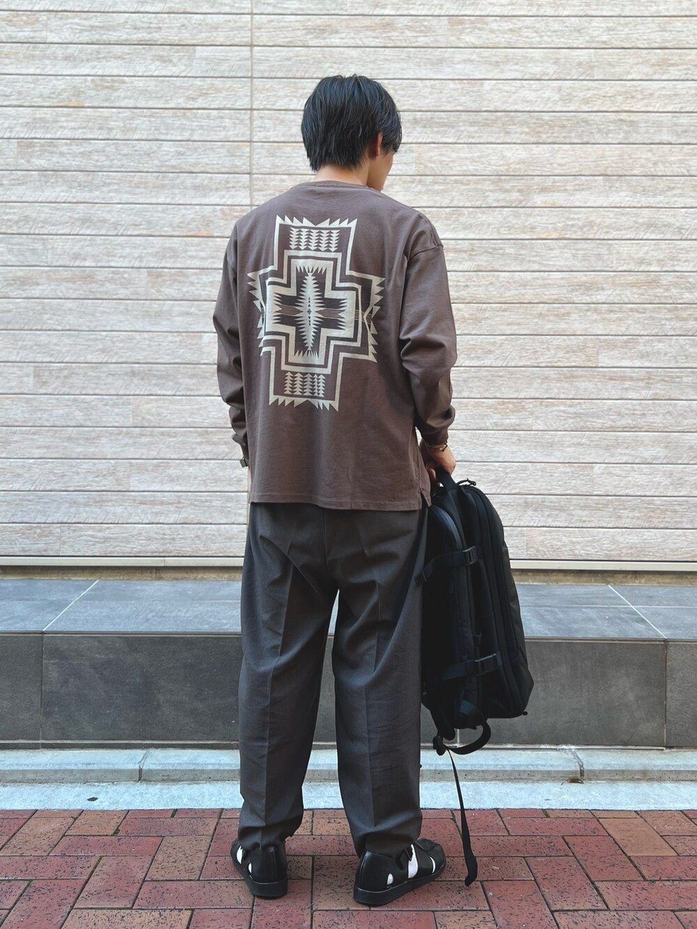 ブラウン系のTシャツ/カットソー、ブラック系のバックパック/リュックを着用したメンズの秋コーディネートの2枚目の写真