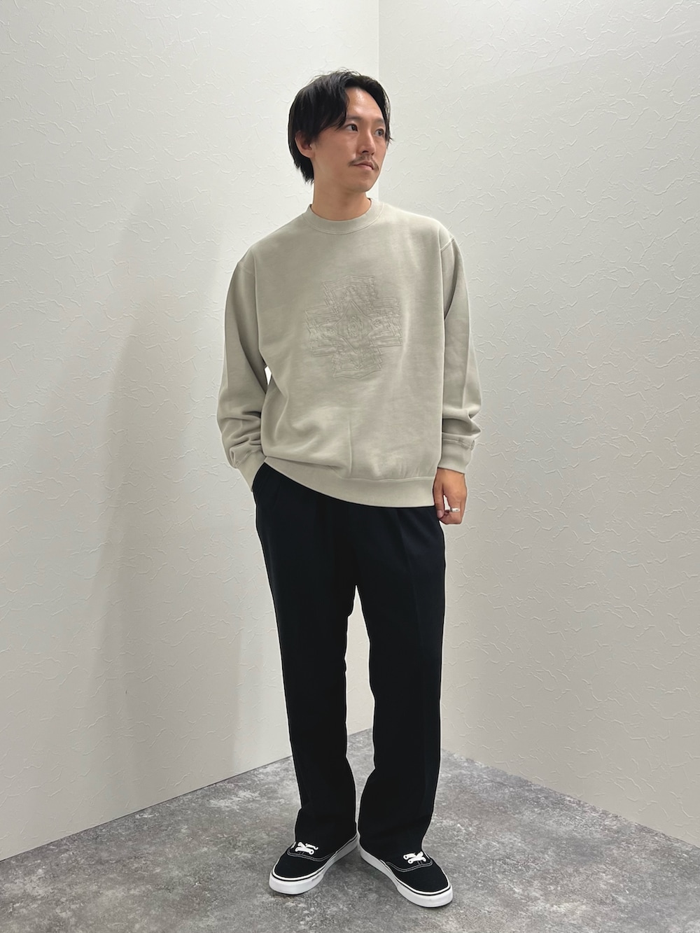 ベージュ系のスウェット、ブラック系のスニーカーを着用したメンズの秋コーディネートの2枚目の写真