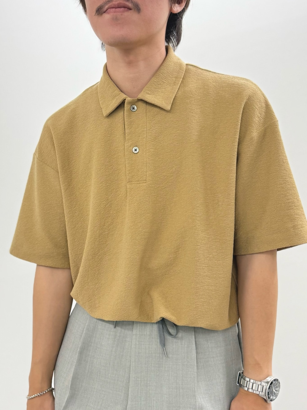 ベージュ系のポロシャツ、ブラック系のサンダルを着用したメンズの夏コーディネートの8枚目の写真