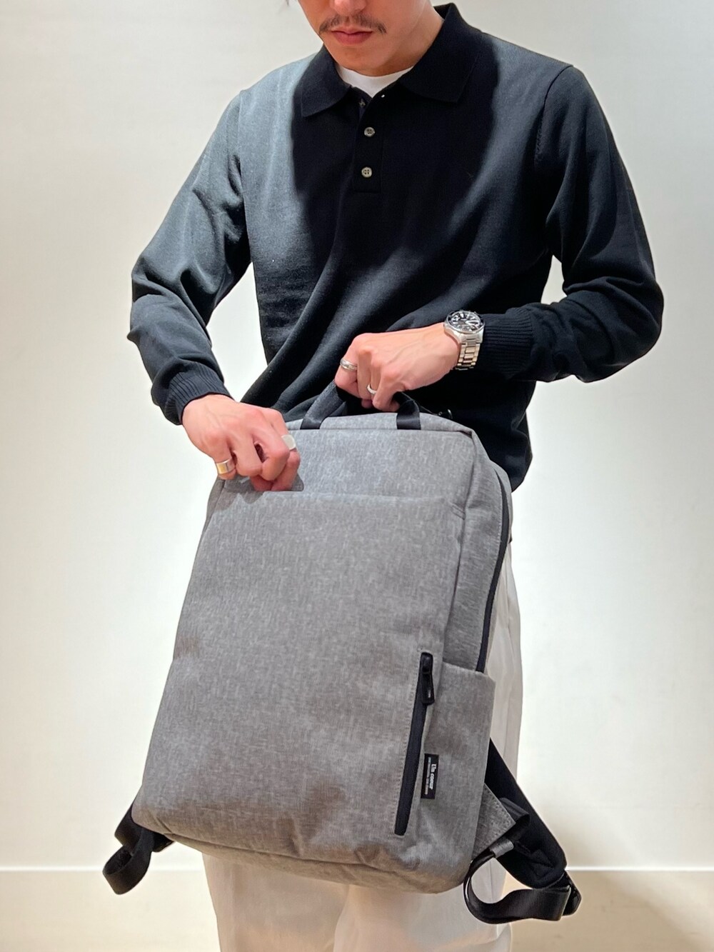 ブラック系のシューズ、ブラック系のニット/セーター、グレー系のバックパック/リュックを着用したメンズの秋コーディネートの5枚目の写真