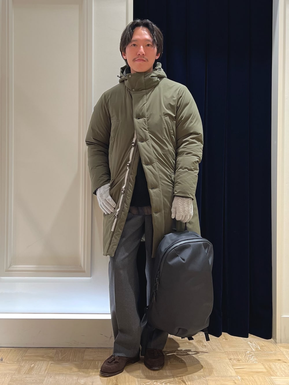 ブラック系のバックパック/リュック、グリーン系のシャツ/ブラウス、グリーン系のダウンジャケット/コートを着用したメンズの冬コーディネートの2枚目の写真