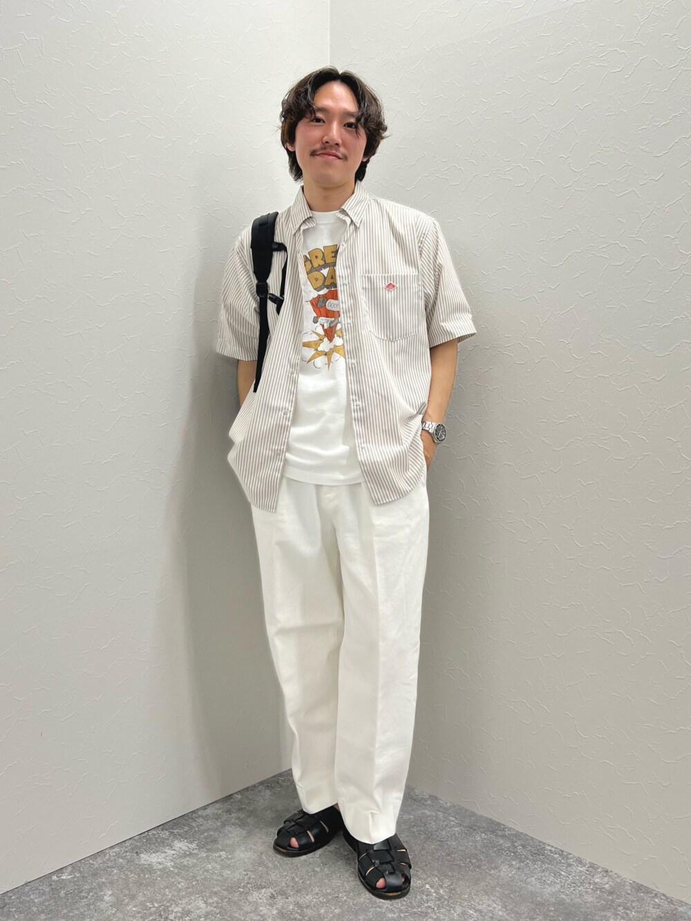 ホワイト系のTシャツ/カットソー、ブラック系のバックパック/リュック、ホワイト系のデニムパンツを着用したメンズの春コーディネートの6枚目の写真