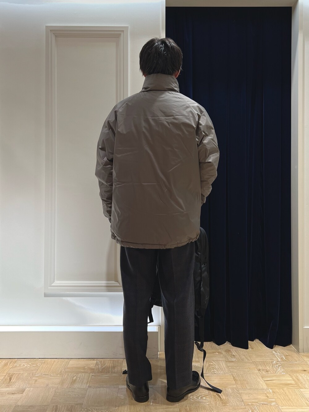 グレー系のダウンジャケット/コート、ブラック系のバックパック/リュックを着用したメンズの冬コーディネートの5枚目の写真