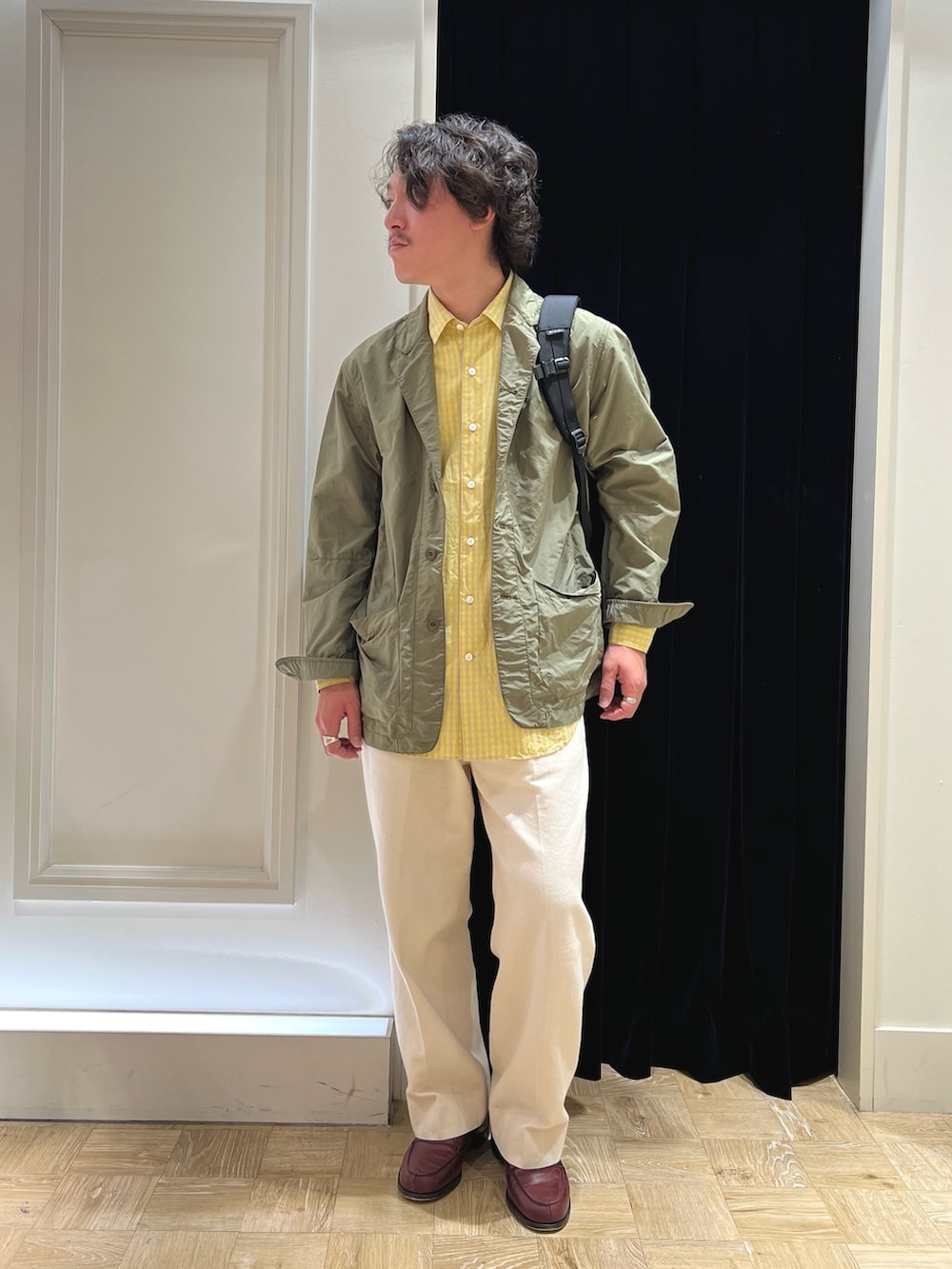 グリーン系のミリタリージャケット、レッド系のローファー、ホワイト系のデニムパンツを着用したメンズの春コーディネートの3枚目の写真