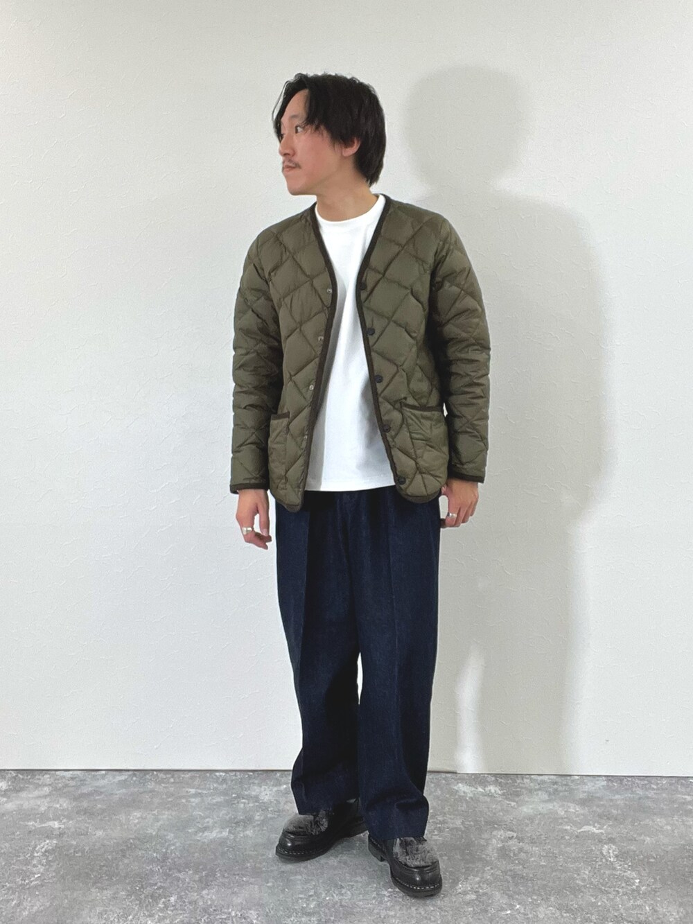 グリーン系のダウンジャケット/コート、ホワイト系のスウェット、ブラック系のブーツを着用したメンズの秋コーディネートの4枚目の写真