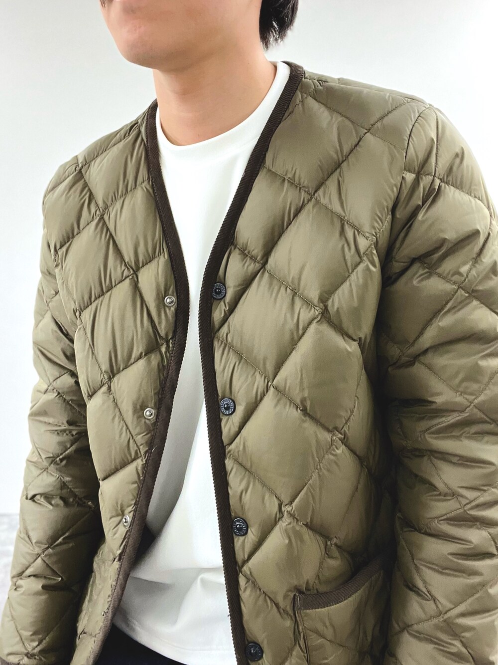 グリーン系のダウンジャケット/コート、ホワイト系のスウェット、ブラック系のブーツを着用したメンズの秋コーディネートの7枚目の写真