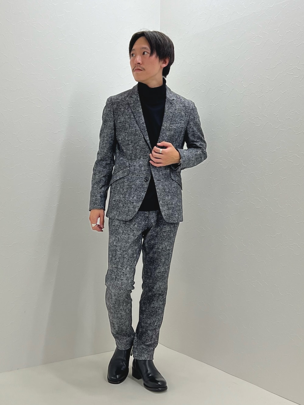 グレー系のテーラードジャケット、グレー系のその他パンツ、ブラック系のTシャツ/カットソーを着用したメンズの秋コーディネートの2枚目の写真