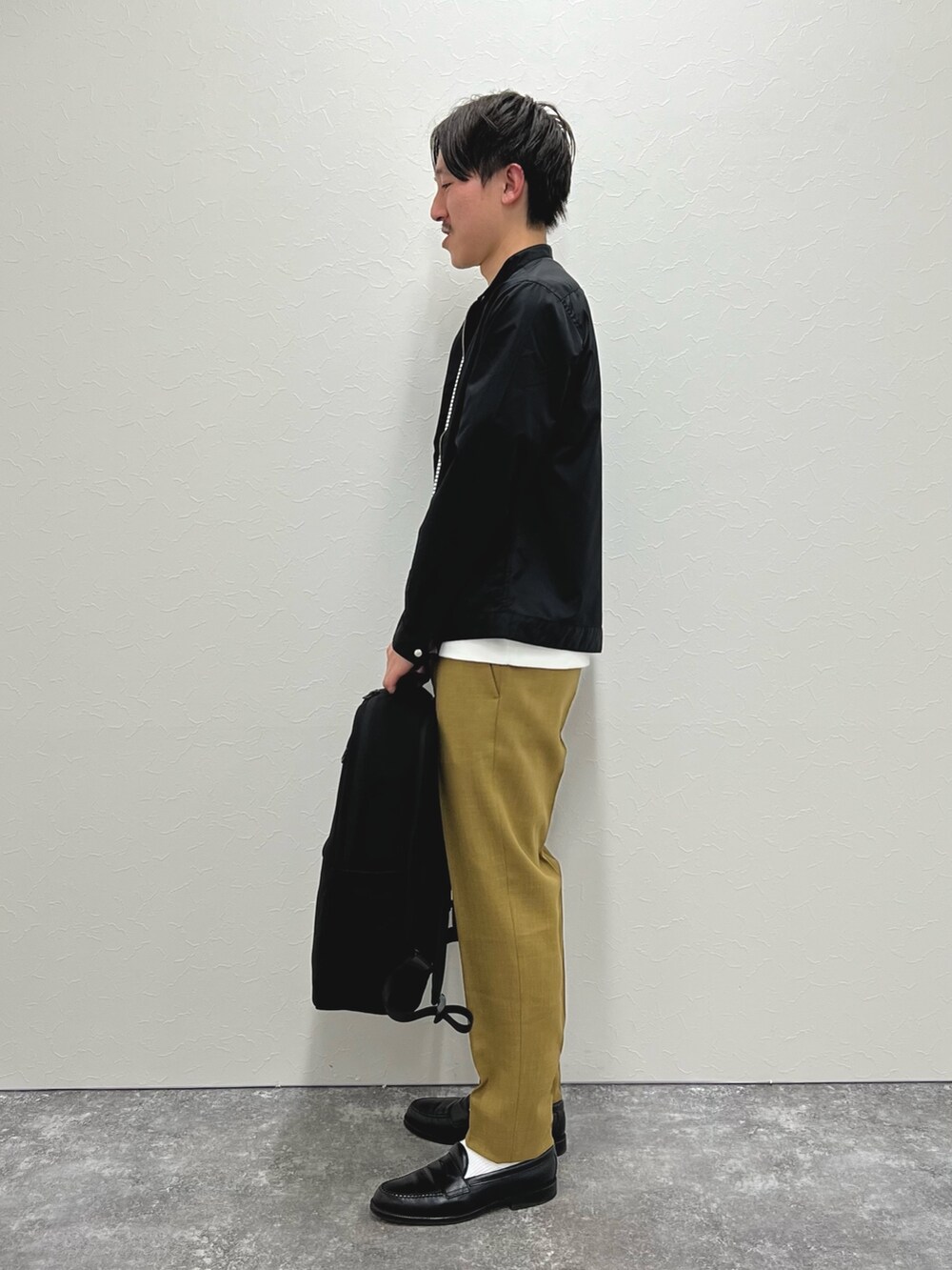 ブラック系のブルゾン、ベージュ系のその他パンツ、ブラック系のサンダルを着用したメンズの春コーディネートの3枚目の写真