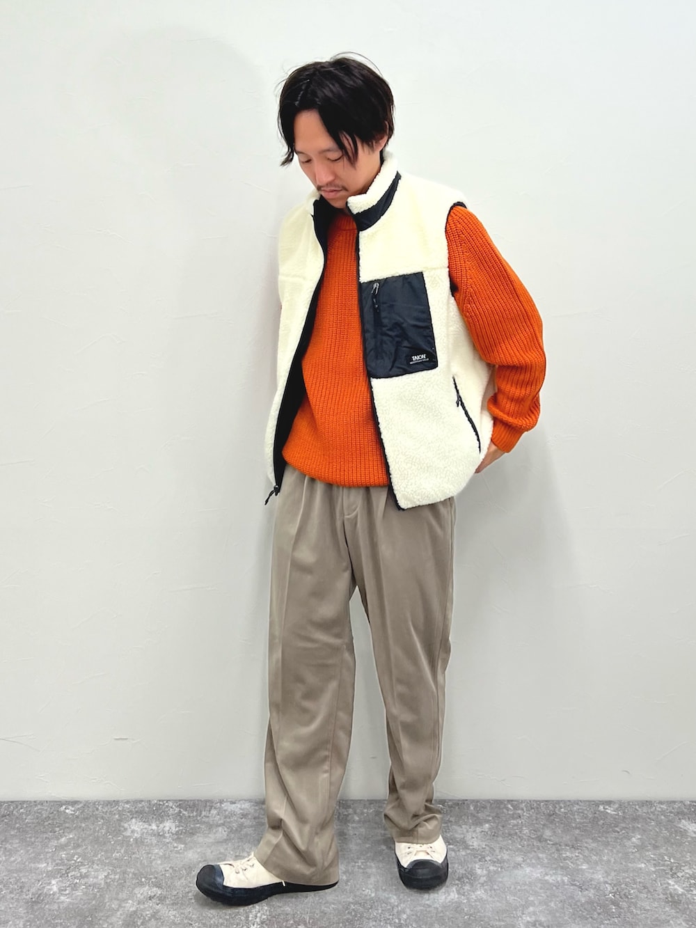 ホワイト系のダウンベスト、ベージュ系のその他パンツを着用したメンズの秋コーディネートの2枚目の写真