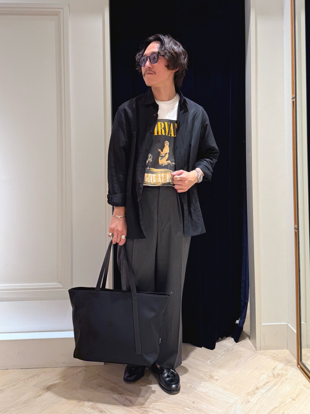 ホワイト系のTシャツ/カットソー、ブラック系のシャツ/ブラウス、ブラック系のトートバッグを着用したメンズの春コーディネートの2枚目の写真